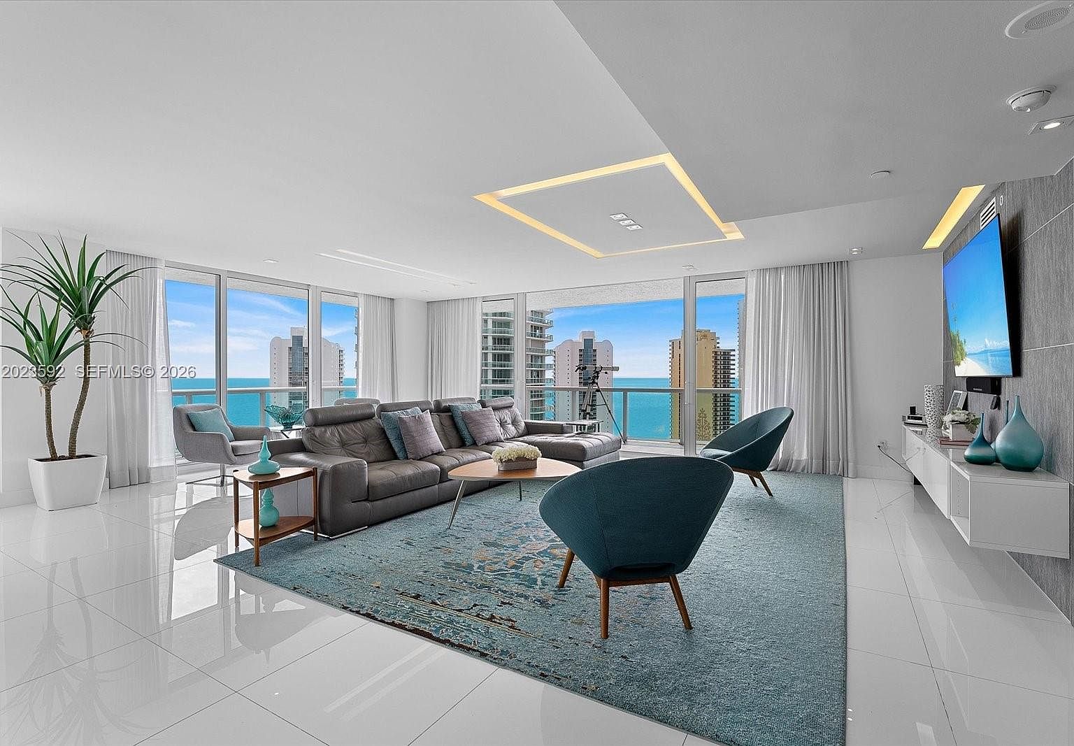 Open-concept living room with floor-to-ceiling glass and the Atlantic horizon visible through the wall of windows
