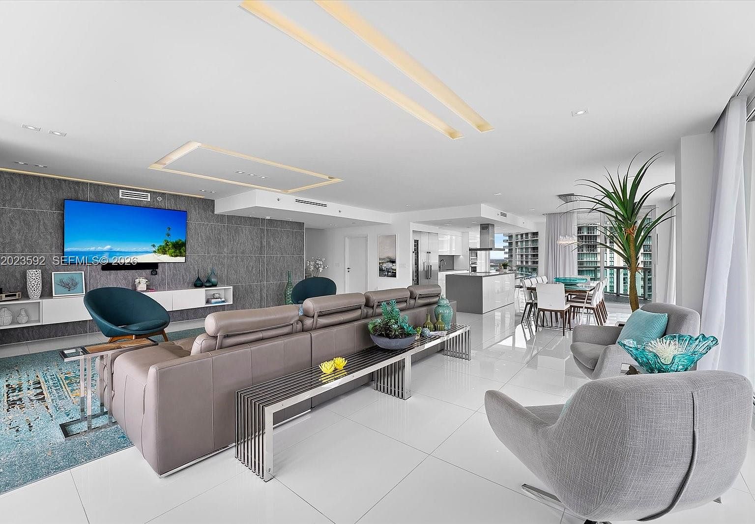 Living area looking back across the great room toward the kitchen wall with custom cabinetry and integrated appliances