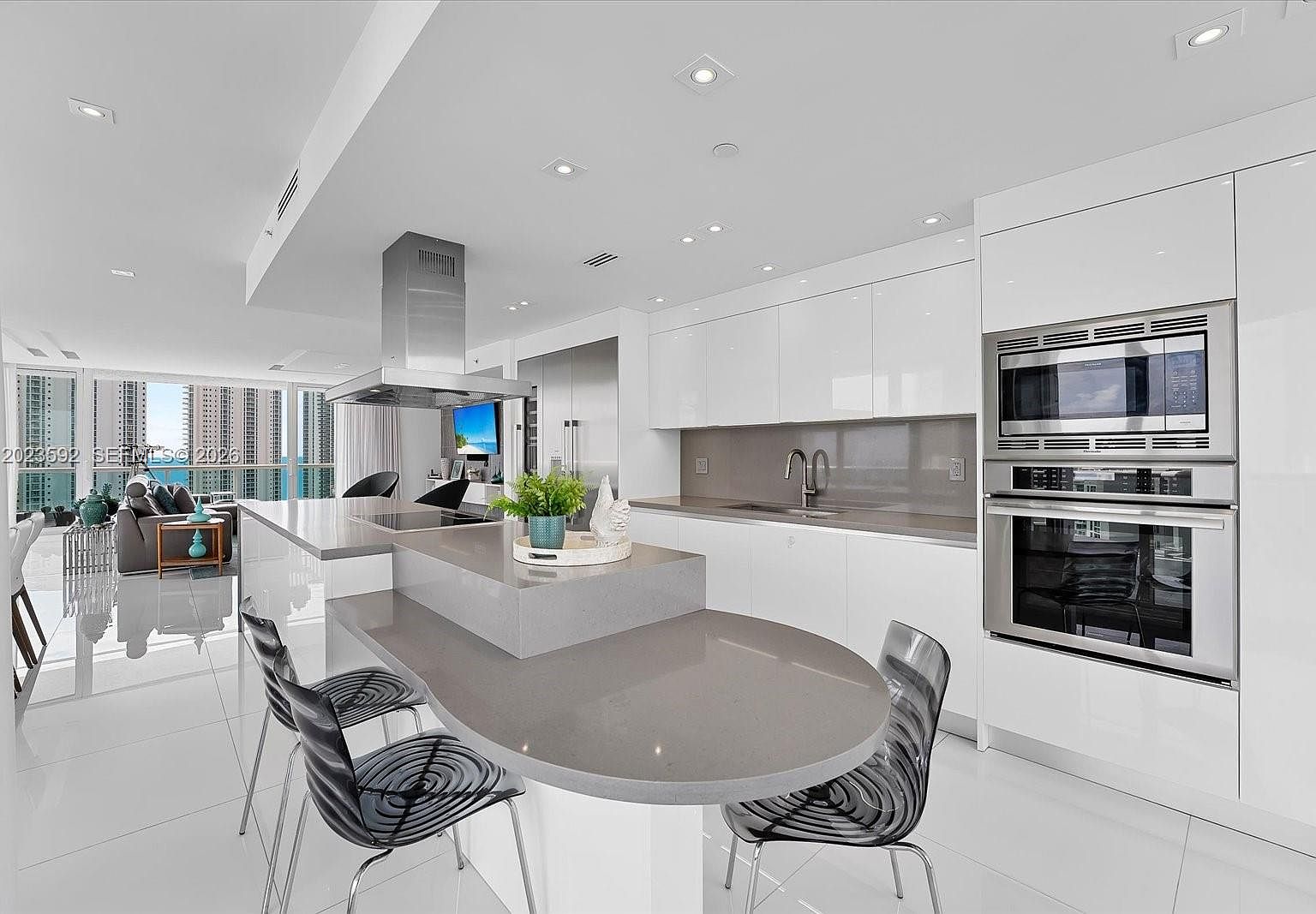 Open-plan kitchen and dining seen from the entry, showing the column-free 30-foot great room